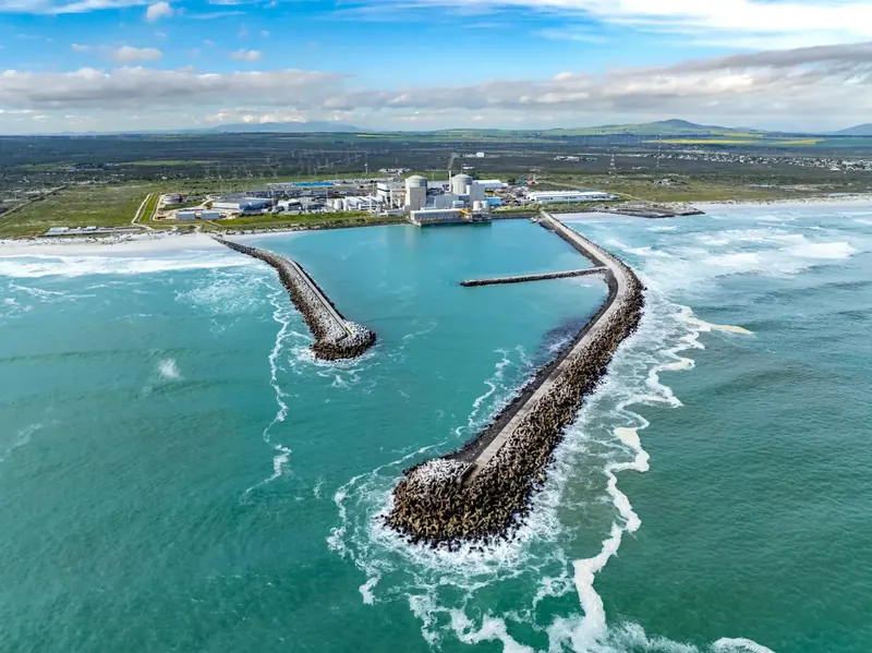 Koeberg Power Station and its harbour breakwaters from the air, with the Atlantic in the foreground